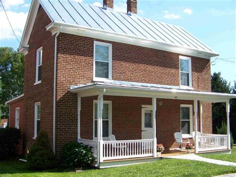 pictures of white brick houses with metal roofs|matching brick and roof colors.